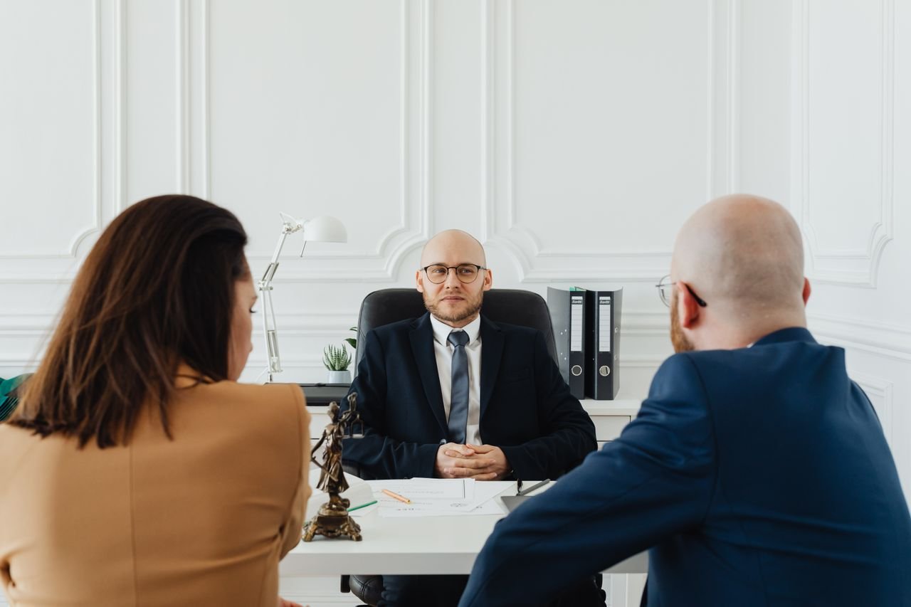 Lawyer meeting with clients in a formal office setting for legal consultation.